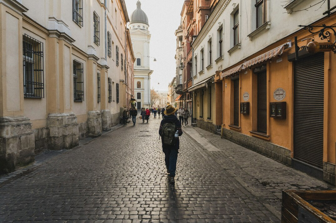 Anonymous person walking away down a quiet European street