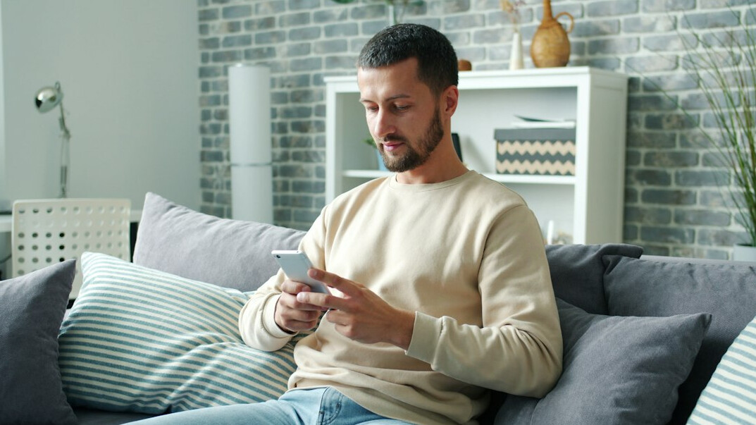 person scrolling smartphone at home
